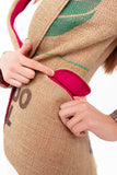 Ein Fräulein zeigt die Veredelung von Taschenklappen einer Damen-Jacke von The Coffee Jacket mit dem hochwertigen österreichischen Loden